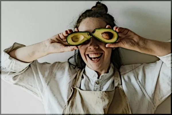 Frau mit zwei Avocado-Hälften